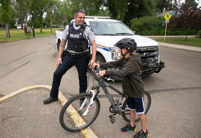 Police officer talking to a child on a bike