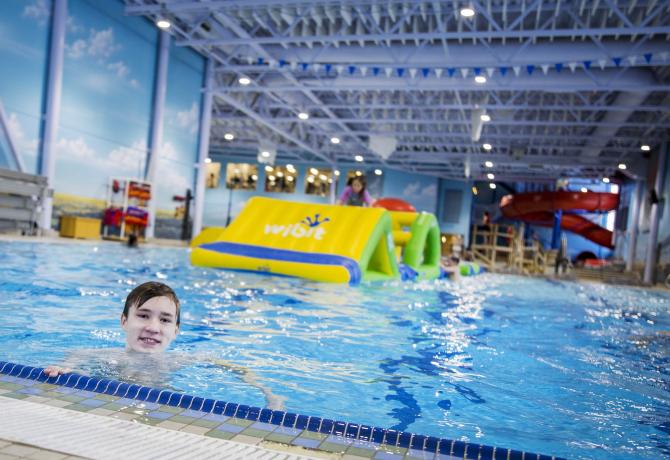 Kids playing and swimming in indoor swimming pool